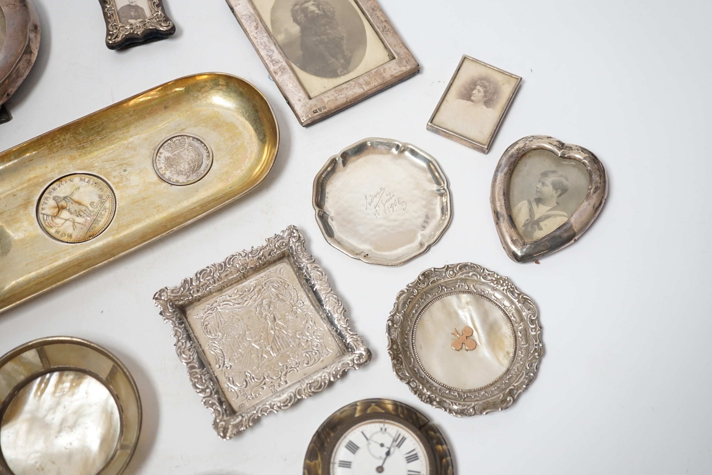 Sundry small silver and white metal items including seven photograph frames, largest 12.5cm, an 800 standard oval dish, inset with three coins, five small dishes and a timepiece.